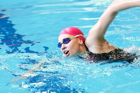 Swimmer – female Person swimming in a large indoor swimming pool
