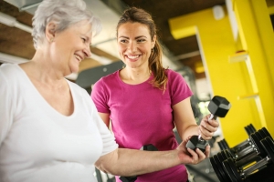 Fitness trainer showing person how to use arm weights