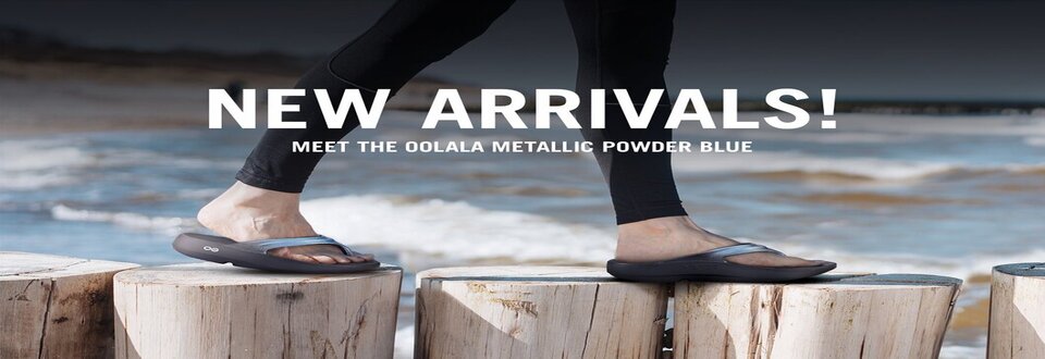 Person standing on wooden posts wearing OOFOS recovery sandals